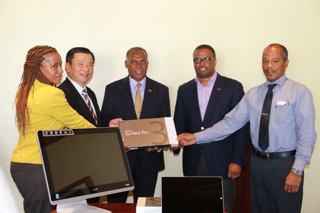 Republic of China (Taiwan)’s Resident Ambassador to St. Kitts and Nevis His Excellency George Gow Wei Chiou (second from left) presents 25 computers, and three Microsoft Surface Pro 3 tablets to Premier of Nevis Hon. Vance Amory (third from right) and Deputy Premier of Nevis and Minister of Health Hon. Mark Brantley (second from right), Permanent Secretary in the Ministry of Health Nicole Slack-Liburd (extreme left) and Hospital Administrator Gary Pemberton (extreme right) at a handing over ceremony at the Alexandra Hospital conference room on July 25, 2016